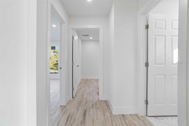 corridor with light hardwood / wood-style floors