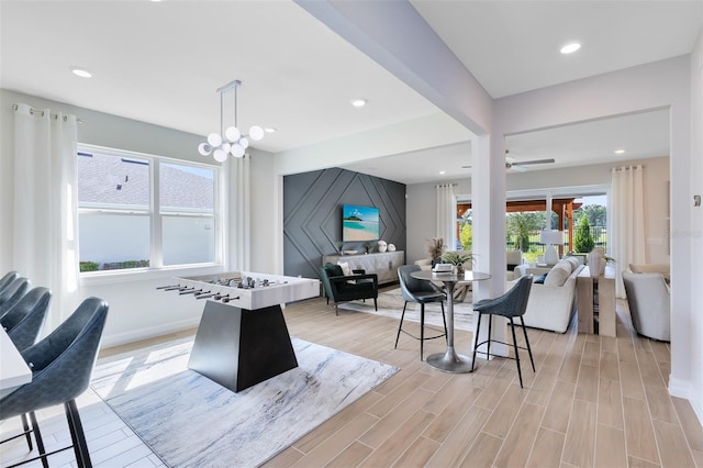 interior space featuring ceiling fan with notable chandelier