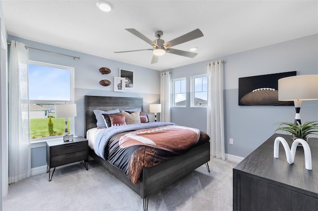 bedroom with ceiling fan and light colored carpet