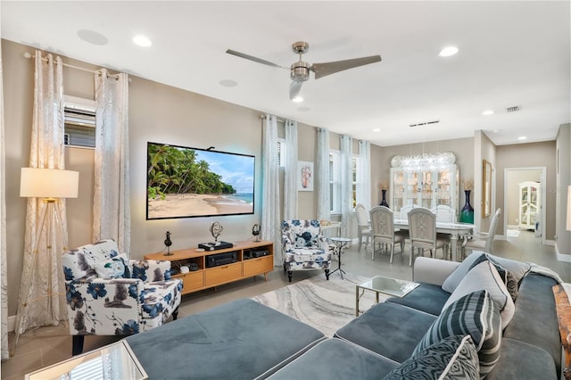 living room with ceiling fan with notable chandelier