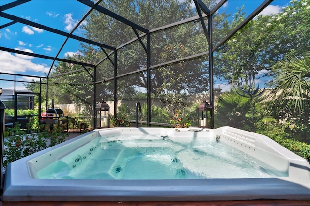 view of pool with a hot tub and glass enclosure