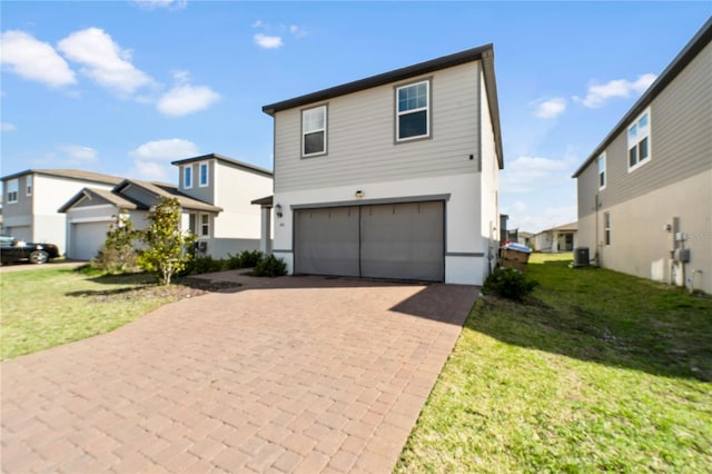 view of front facade featuring an attached garage, a residential view, a front lawn, and decorative driveway