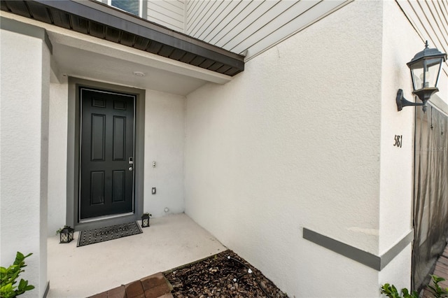 property entrance featuring stucco siding