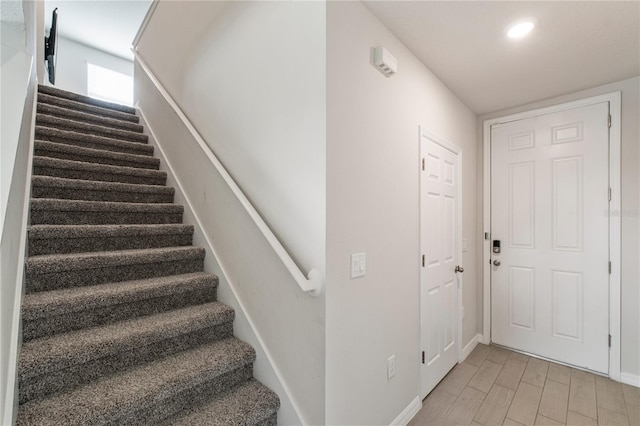 stairway featuring baseboards and wood finished floors