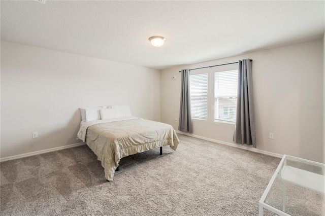 carpeted bedroom featuring baseboards and a textured ceiling