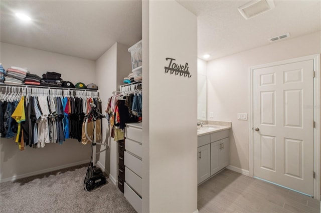 walk in closet featuring visible vents and a sink