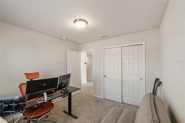 carpeted home office with a textured ceiling, visible vents, and baseboards