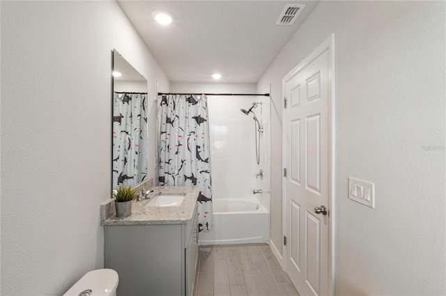 full bath with toilet, wood finished floors, visible vents, vanity, and shower / bathtub combination with curtain