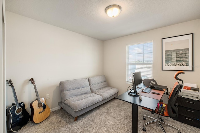 office area with carpet floors, a textured ceiling, and baseboards