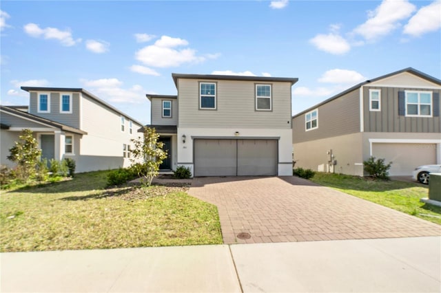 view of front of property with an attached garage, decorative driveway, and a front yard