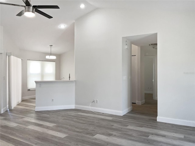 spare room featuring light hardwood / wood-style flooring, ceiling fan, and vaulted ceiling