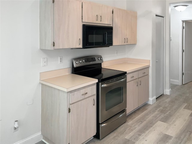 kitchen featuring stainless steel electric stove, light brown cabinetry, and light hardwood / wood-style flooring