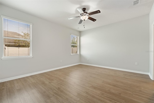 spare room with ceiling fan, hardwood / wood-style flooring, and a healthy amount of sunlight