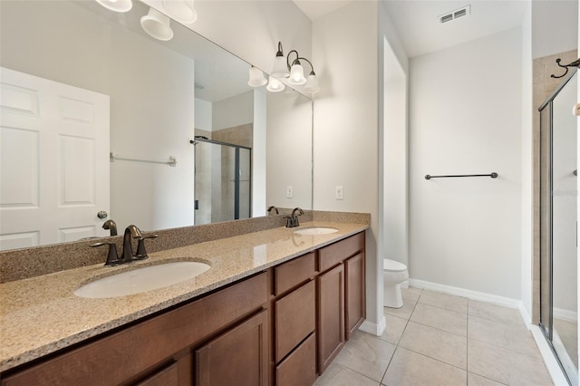 bathroom with tile patterned flooring, vanity, a shower with door, and toilet