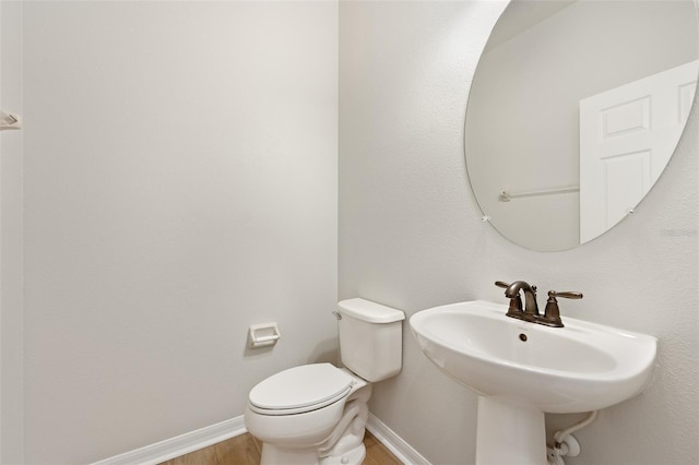 bathroom featuring hardwood / wood-style flooring, sink, and toilet