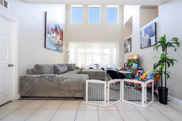 living room with light tile patterned floors and a towering ceiling