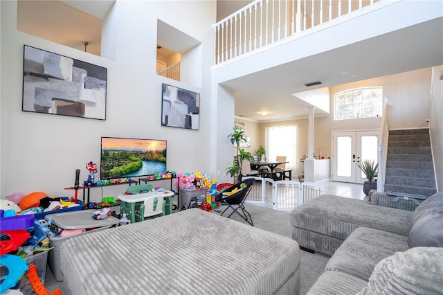 living room featuring a towering ceiling, light colored carpet, and french doors