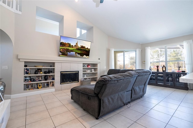 tiled living room featuring a tiled fireplace and high vaulted ceiling