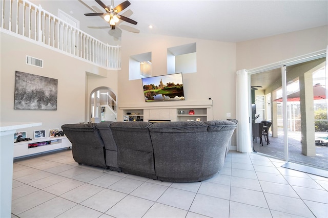 tiled living room featuring ceiling fan and high vaulted ceiling