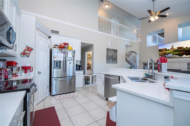 kitchen featuring white cabinetry, sink, light tile patterned floors, and stainless steel appliances