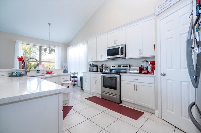 kitchen featuring white cabinetry, hanging light fixtures, sink, and appliances with stainless steel finishes