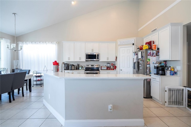 kitchen with light tile patterned flooring, white cabinetry, an inviting chandelier, an island with sink, and stainless steel appliances