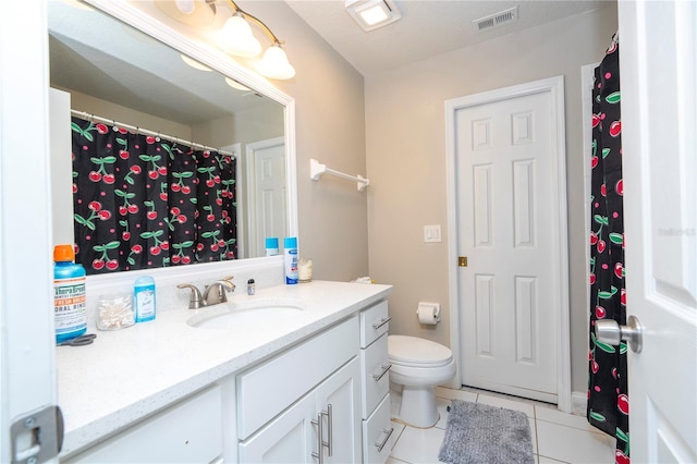 bathroom with tile patterned flooring, vanity, and toilet