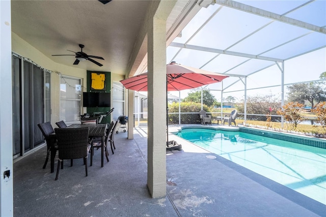 view of swimming pool with ceiling fan, a lanai, and a patio area