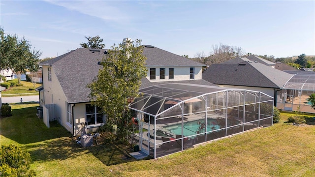 rear view of house with a patio, a lanai, and a lawn