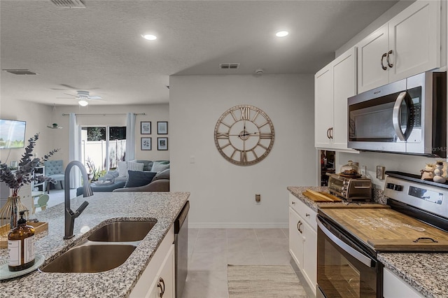 kitchen featuring sink, a textured ceiling, stainless steel appliances, and white cabinets