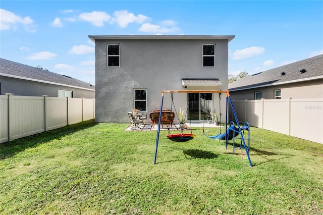 back of property with a yard and a patio area