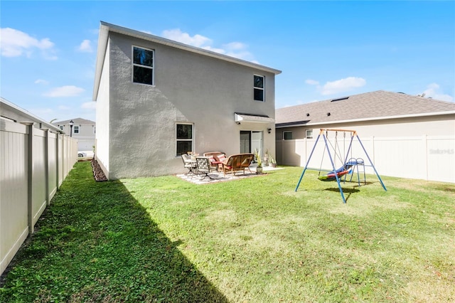 back of property featuring a playground, a patio, and a yard