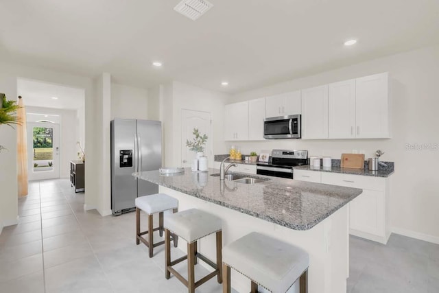 kitchen featuring white cabinetry, sink, an island with sink, and appliances with stainless steel finishes