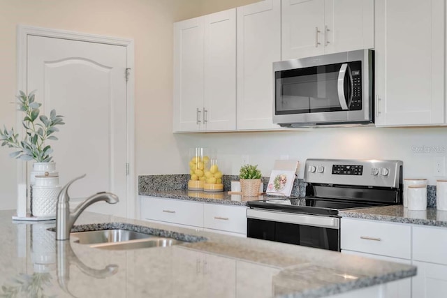 kitchen featuring light stone counters, white cabinets, and appliances with stainless steel finishes