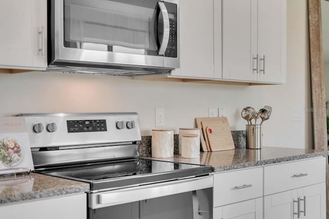 kitchen with white cabinetry, appliances with stainless steel finishes, and stone countertops