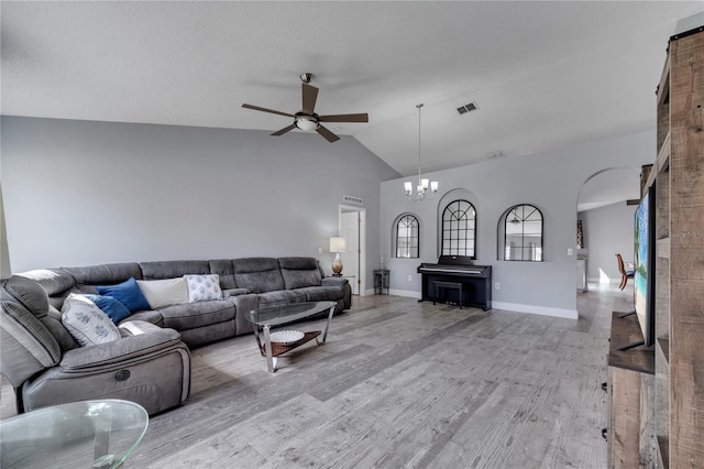 living area featuring visible vents, vaulted ceiling, ceiling fan with notable chandelier, light wood-style floors, and arched walkways