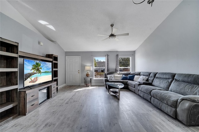 living area featuring wood finished floors, baseboards, high vaulted ceiling, ceiling fan, and a textured ceiling