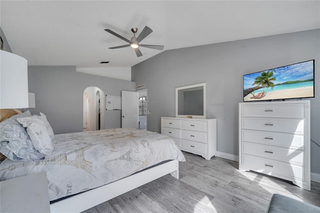 bedroom with visible vents, ceiling fan, vaulted ceiling, light wood-style flooring, and arched walkways