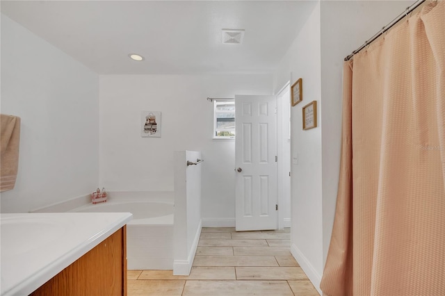 full bathroom featuring recessed lighting, baseboards, a garden tub, and vanity