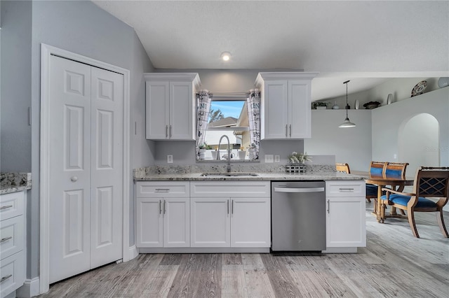 kitchen featuring light stone counters, white cabinetry, light wood-style flooring, a sink, and dishwasher