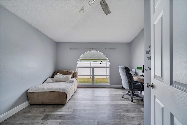 office featuring baseboards, a textured ceiling, and wood finished floors