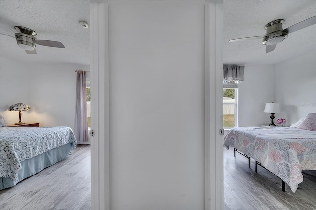 bedroom featuring multiple windows, wood finished floors, and a textured ceiling