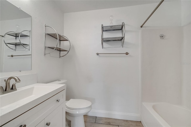 bathroom featuring vanity, toilet, tub / shower combination, and baseboards