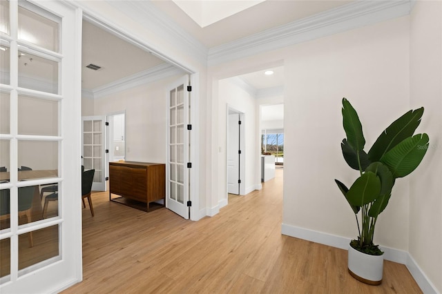 corridor featuring ornamental molding, light hardwood / wood-style flooring, and french doors