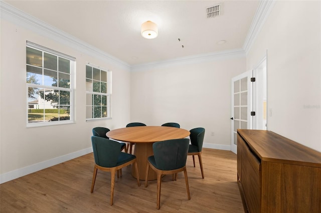 dining space featuring crown molding and light hardwood / wood-style flooring