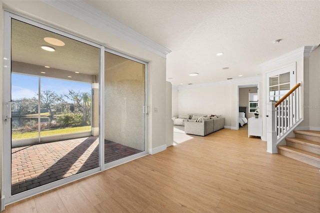 interior space with crown molding, light hardwood / wood-style flooring, and a textured ceiling