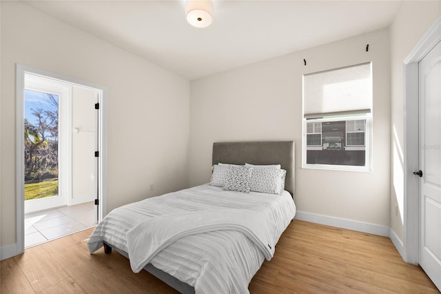 bedroom with access to exterior and light wood-type flooring