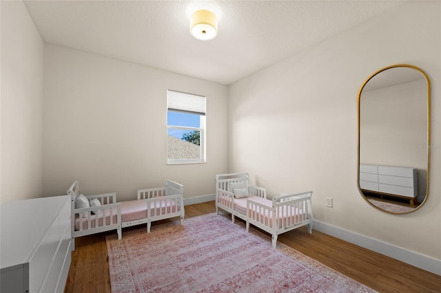 bedroom with wood-type flooring and a textured ceiling