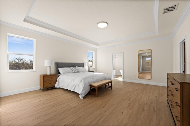 bedroom featuring ornamental molding, a raised ceiling, and light wood-type flooring