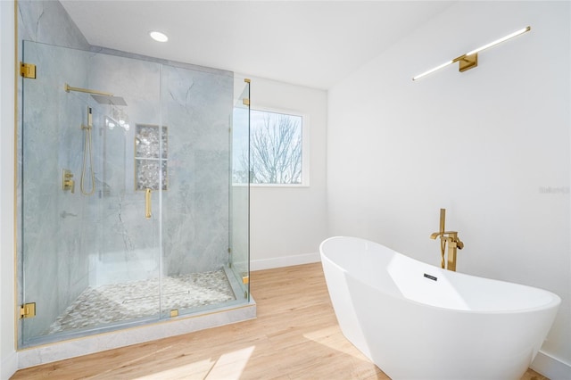 bathroom with wood-type flooring and separate shower and tub